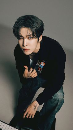 a young man leaning on top of a piano