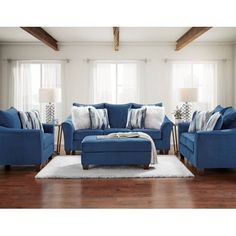 a living room with blue couches and pillows