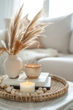 a table with a vase, candle and some rocks on it in front of a couch