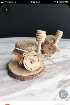 two honey jars tied with twine on top of a piece of wood