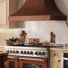 a stove top oven sitting inside of a kitchen next to an oven with pots and pans on it