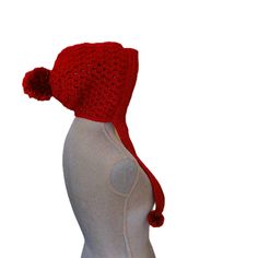 a crocheted red hat on top of a mannequin's head