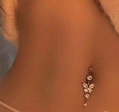 the back of a woman's stomach with a butterfly pendant on it