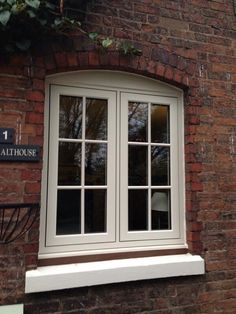 a brick building with two windows and a sign on the side