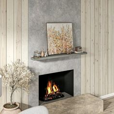 a living room with a fire place in the center and wood paneling on the walls