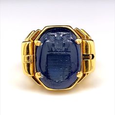 A retro reversible sapphire signet ring 18 karat yellow gold, circa 1940. This unusual and ingeniously crafted ring comprises of a deep blue cabochon sapphire, engraved with a seal to one side with a smooth polished cabochon dome to the other. The wearer can choose to either wear the sapphire on its smooth polished dome or by using its clever integrated side release mechanism to flip over the sapphire to reveal its seal engraving. This ring really has an impressive wow factor! UK finger N or US finger size 7 Dimensions: Height 1.9cm x 2.1cm width x 0.7cm depth Components: Cabochon seal engraved sapphire, 18 karat yellow gold. Condition - Overall the condition of the ring is really good in keeping with its general age; there are slight abrasions throughout to the surface of the gold and to Luxury Sapphire Signet Ring As Promise Ring, Formal Gold Cabochon Signet Ring, Vintage Yellow Gold Sapphire Ring Collectible, Antique Signet Ring With 17 Jewels For Formal Occasions, Classic Yellow Gold Sapphire Ring Collector's Item, Antique Embellished Signet Ring For Formal Occasions, Vintage Gold Sapphire Ring Stamped 14k, Antique Cabochon Sapphire Ring For Formal Events, Vintage Gold Sapphire Cabochon Ring