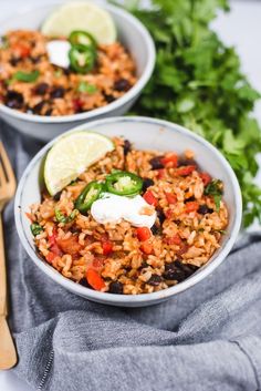 two bowls filled with mexican rice and vegetables