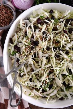 a white bowl filled with coleslaw and olives