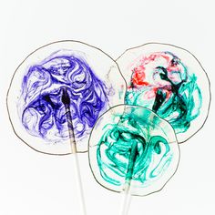 two lollipops with colored swirl designs on them sitting next to each other