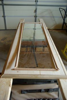 a wooden table with glass on top and some tools in front of it, ready to be worked on