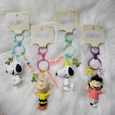 three keychains with cartoon characters on them sitting on a white furnishing