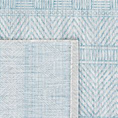 two blue and white rugs on top of each other, one with a square in the middle