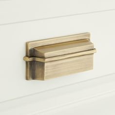 a close up of a door handle on a white painted wall with wood grained finish