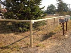 the fence is made of metal wire and has a mailbox on top of it