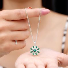 Product Details The lab created emerald flower cocktail pendant with Diamond is a wearable oasis, capturing the beauty and magic of nature in a stunning piece of jewelry. The pendant features a 5 MM emerald center stone flower, its petals adorned with sparkling Diamond and pear-shaped emerald stones. As you move, the pendant comes alive, its emerald petals shimmering and its Diamond stones twinkling like stars. This pendant is a perfect gift for a woman who loves the beauty of nature and the mag Diamond Locket, Lab Created Emerald, Sparkling Diamond, Emerald Necklace, Emerald Stone, Sparkle Diamonds, Diamond Stone, Stone Pendants, Pear Shaped