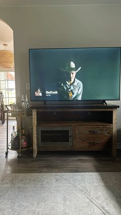 a flat screen tv sitting on top of a wooden entertainment center in a living room