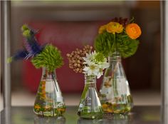 three vases filled with different types of flowers