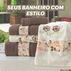 towels are stacked on top of each other in front of a window with the words seus banheiro com estilo