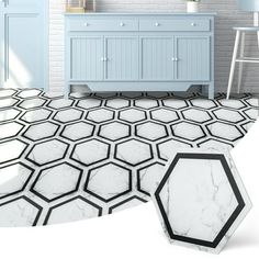 a white and blue bathroom with hexagonal tiles on the floor next to a sink