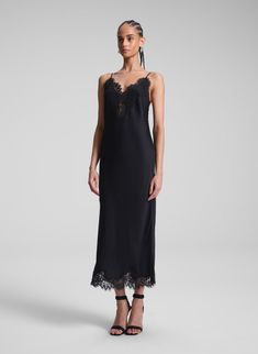 The Lennon Dress is crafted from lustrous black satin with captivating fluidity. This midi-length slip silhouette offers a more directional take on a classic, featuring delicate lace trimming along the neckline, hem, and low back, creating an alluring interplay between masculinity and femininity. Complete with slim, adjustable straps, it strikes a perfect balance between elegance and modern edge. Shop Dresses. Styling Tip: Pair it with minimalist heels and sculptural earrings, finishing with a s Evening Slip Dress With Lace Trim And Spaghetti Straps, Satin Midi Dress With Lace Trim For Evening, Satin Midi Dress With Lace Trim, Silk Midi Dress With Lace Trim For Party, Evening Satin Midi Dress With Lace Trim, Chic Formal Slip Dress With Lace Trim, Chic Evening Slip Dress With Lace Trim, Black Lace Trim Slip Dress For Formal Occasions, Spring Formal Slip Dress With Lace Trim