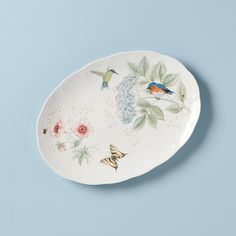 a plate with flowers and butterflies painted on the side, against a light blue background