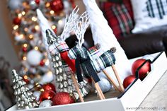 christmas decorations are displayed in a box on the table