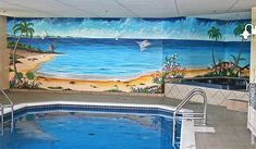 an indoor swimming pool with murals on the wall