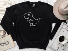 "Dinosaur Birthday Sweatshirt, Dinosaur Sweatshirt, Dino Hoodie, Dinosaur Family Sweater, Dino Sweater, Cute Dino Shirt, Funny Dino Sweater ☀️☀️☀️☀️☀️ Everything in our shop is hand crafted and made to order. If you want different color or size contact me! If you would like something custom made to fit your personal style please message me and I will do everything to get you that something special. ---How To Order--- ⭐️Please, check and review all photos ⭐️Choose your t-shirt size and color ⭐️En Dinosaur Print Long Sleeve Tops For Winter, Winter Long Sleeve Tops With Dinosaur Print, Casual Dinosaur Print Crew Neck Sweatshirt, Winter Dinosaur Print Crew Neck Top, Dino Sweatshirt, Dino Sweater, Dino Hoodie, Dinosaur Sweatshirt, Dinosaur Family