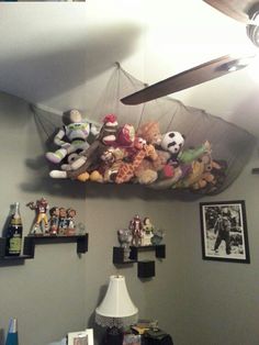 a room with stuffed animals on the ceiling and pictures hanging from the ceiling above it