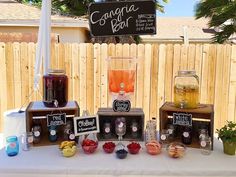 a table topped with drinks and fruit next to a wooden sign that reads congrata bar