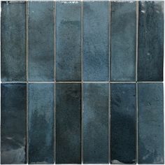 a blue tile wall that is made up of several different shades of gray and black tiles