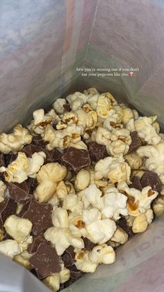 a bag filled with chocolate covered popcorn sitting on top of a table