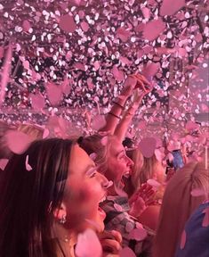 a group of people at a party with confetti falling from the ceiling and in the air