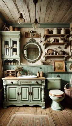 an old fashioned bathroom with green cabinetry and white toilet in the center, surrounded by wooden flooring