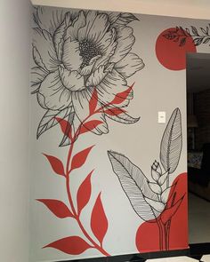 a large flower painted on the side of a wall in a living room with red accents