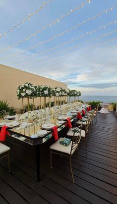 a long table set up with white and red napkins