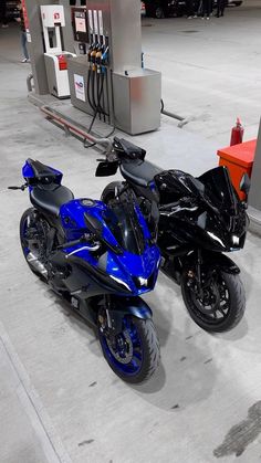 two motorcycles parked next to each other at a gas station