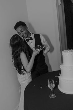 a bride and groom sharing a kiss in front of their wedding cake