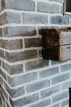 a brick wall with a wooden box attached to it