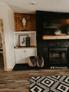 a living room with a fireplace, television and rugs on the floor in front of it