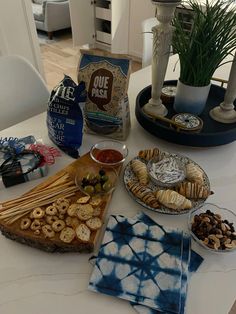 a table topped with plates and bowls filled with food on top of a white table