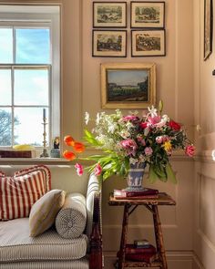 a living room filled with furniture and flowers in vases on top of a table