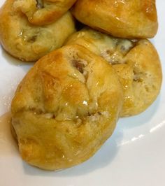 four pastries are sitting on a white plate