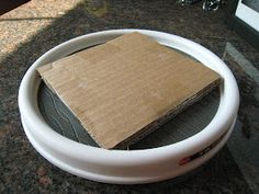 a cardboard box is in the middle of a white bowl on a counter top with other items around it