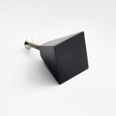 a black square object with a screw sticking out of it's center piece on a white background