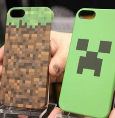 two people holding up cell phones that have been made to look like minecraft characters