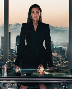 a woman standing in front of a desk with a laptop on it