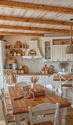 a kitchen filled with lots of wooden furniture and white walls, along with an open floor plan