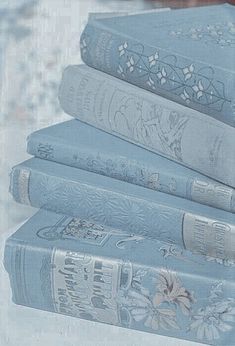 four blue books are stacked on top of each other