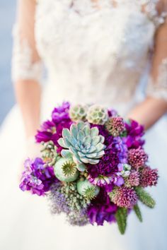 a bride holding a purple bouquet with succulents